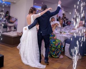 Entrada de los recién casados al comedor nupcial, saludando a los invitados mientras agitan las servilletas
