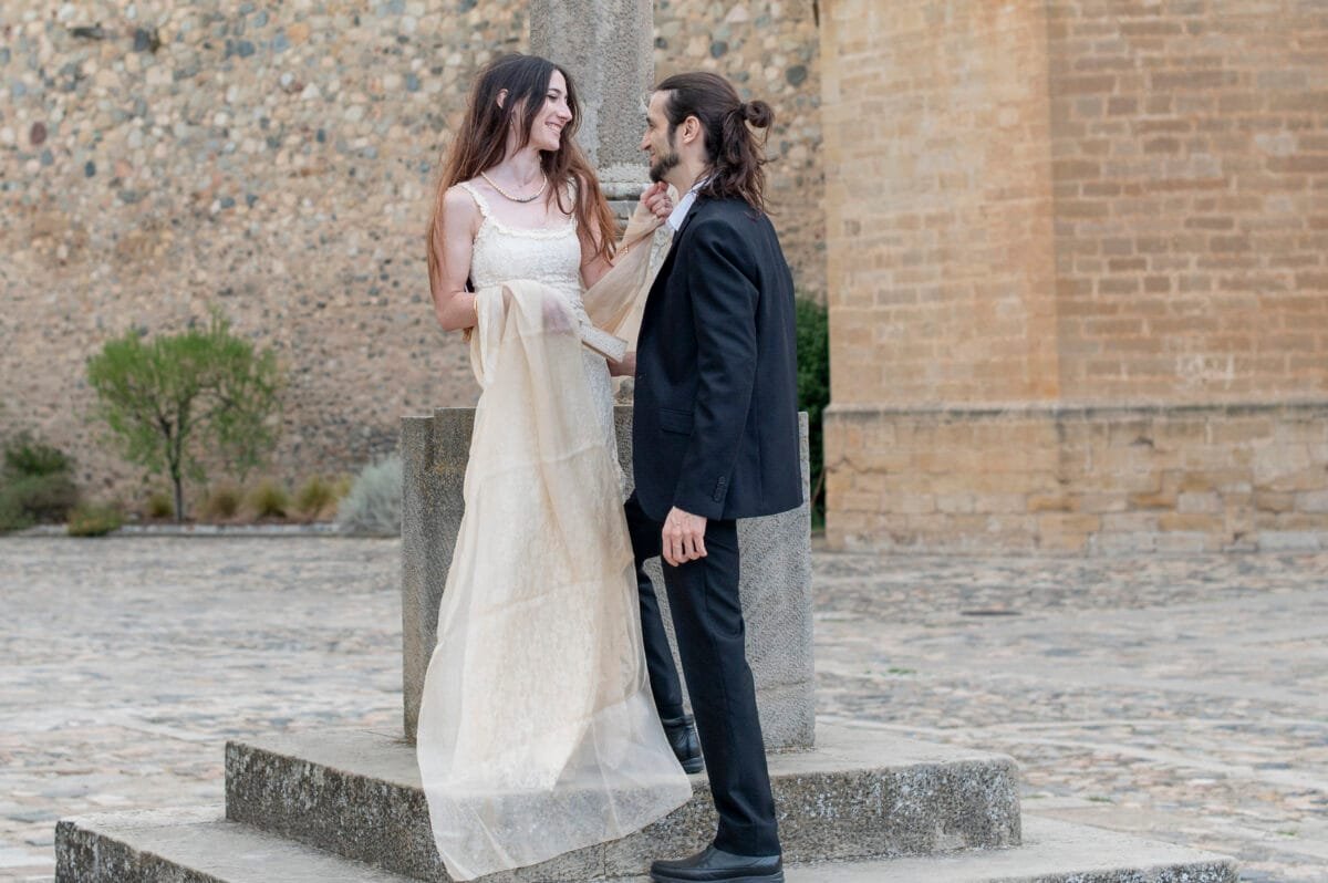 Novia sonriendo con el chal al viento en la plaza de Poblet
