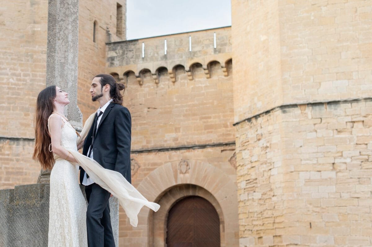 Pareja ante las torres de la Puerta Real con el chal al viento
