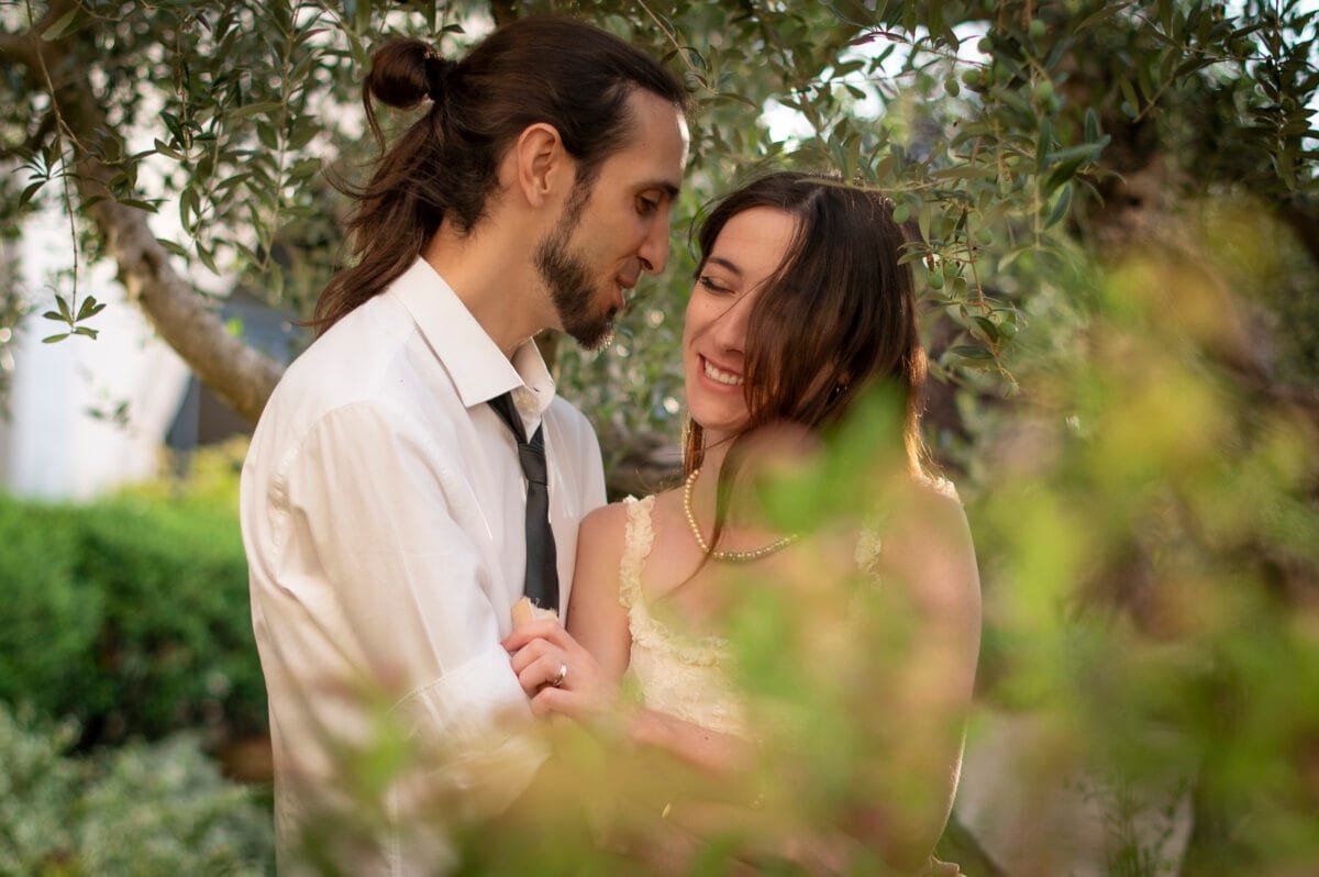 Pareja sonriendo entre olivos, preboda en Poblet