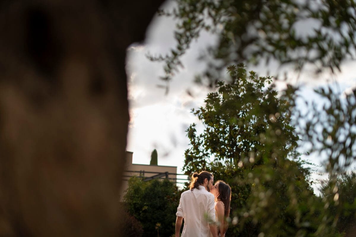Beso a contraluz entre árboles al atardecer en Poblet