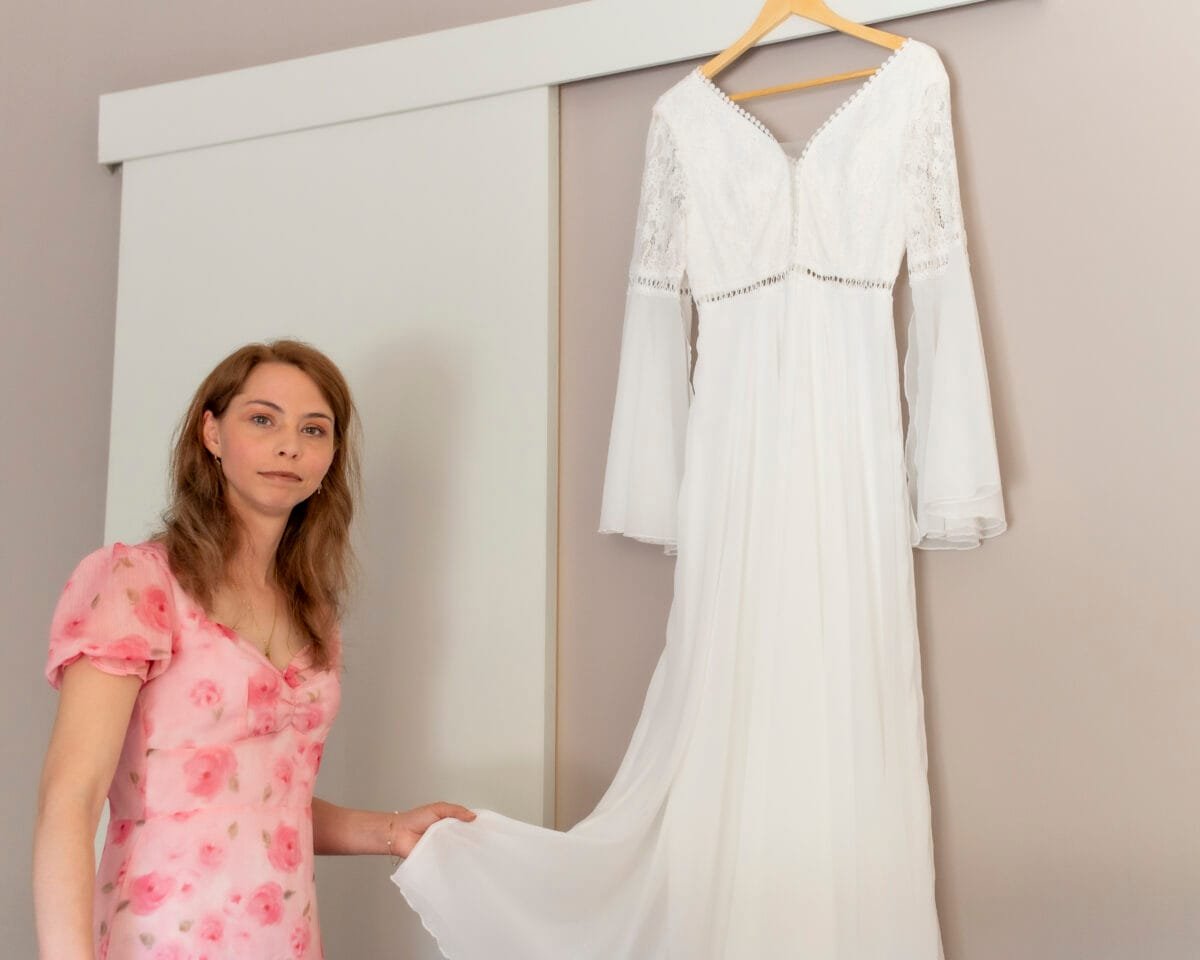 La novia junto a su vestido de encaje antes de vestirse