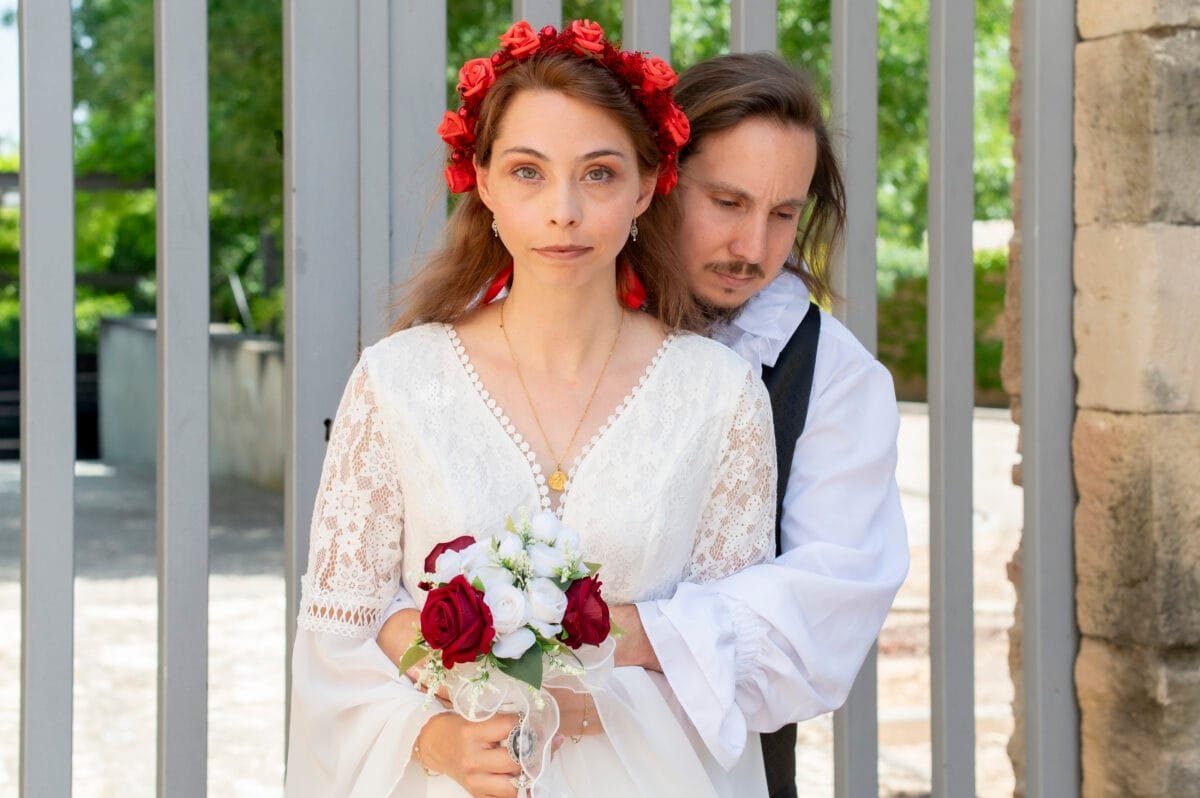 Los novios con el ramo de rosas rojas y blancas en Poblet
