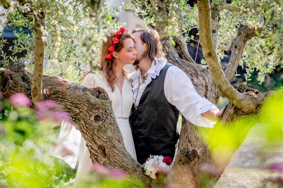 Beso de los novios entre las ramas de un olivo centenario