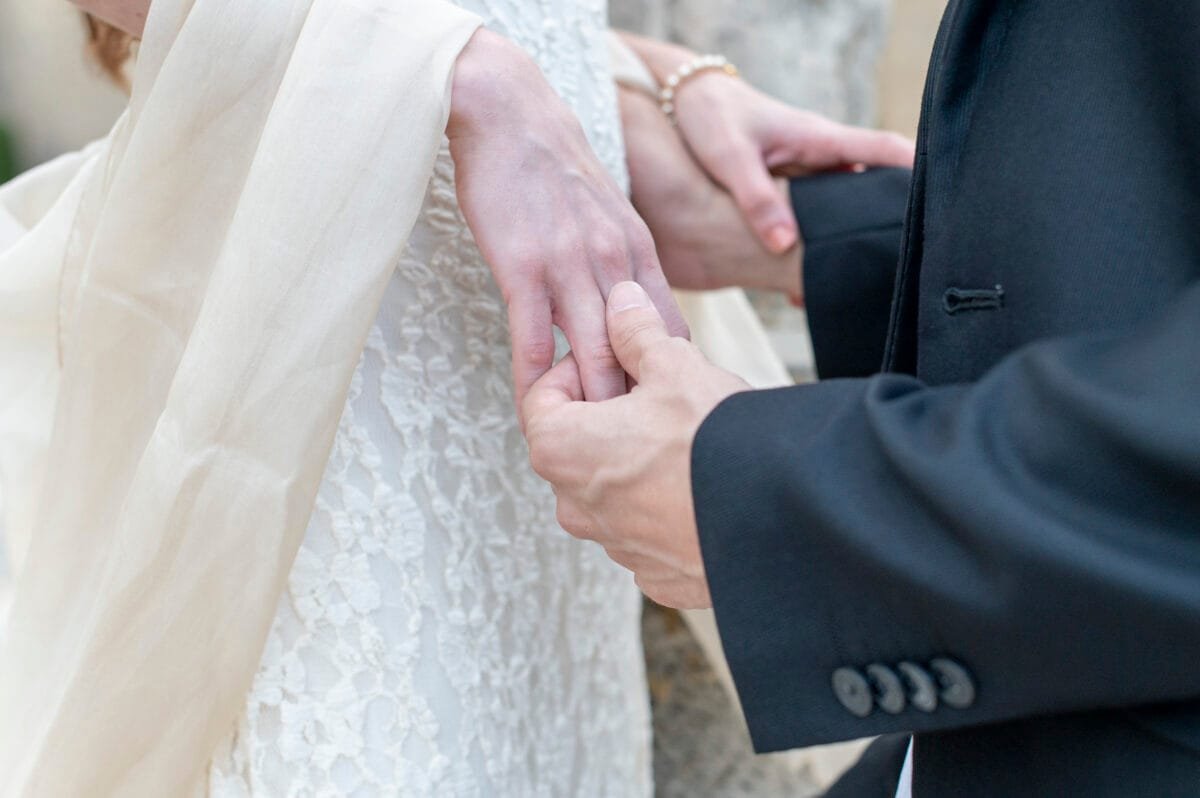 Detalle de las manos de la pareja con el chal de la novia